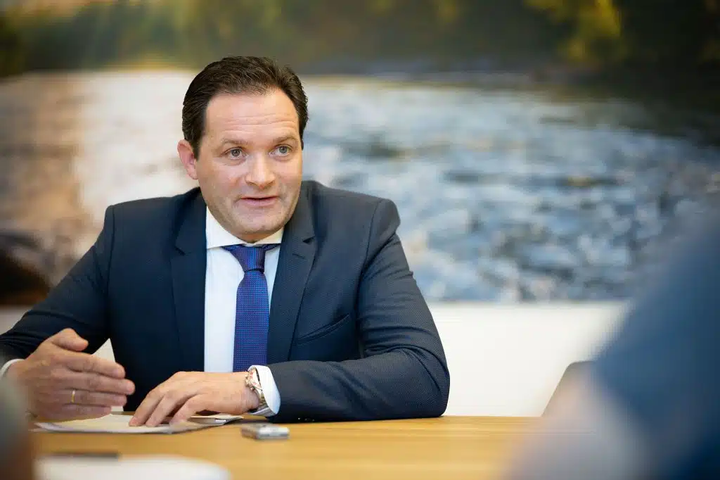 Bundesminister Norbert Tutschnig, der an einem Tisch sitzt und etwas erklärt.